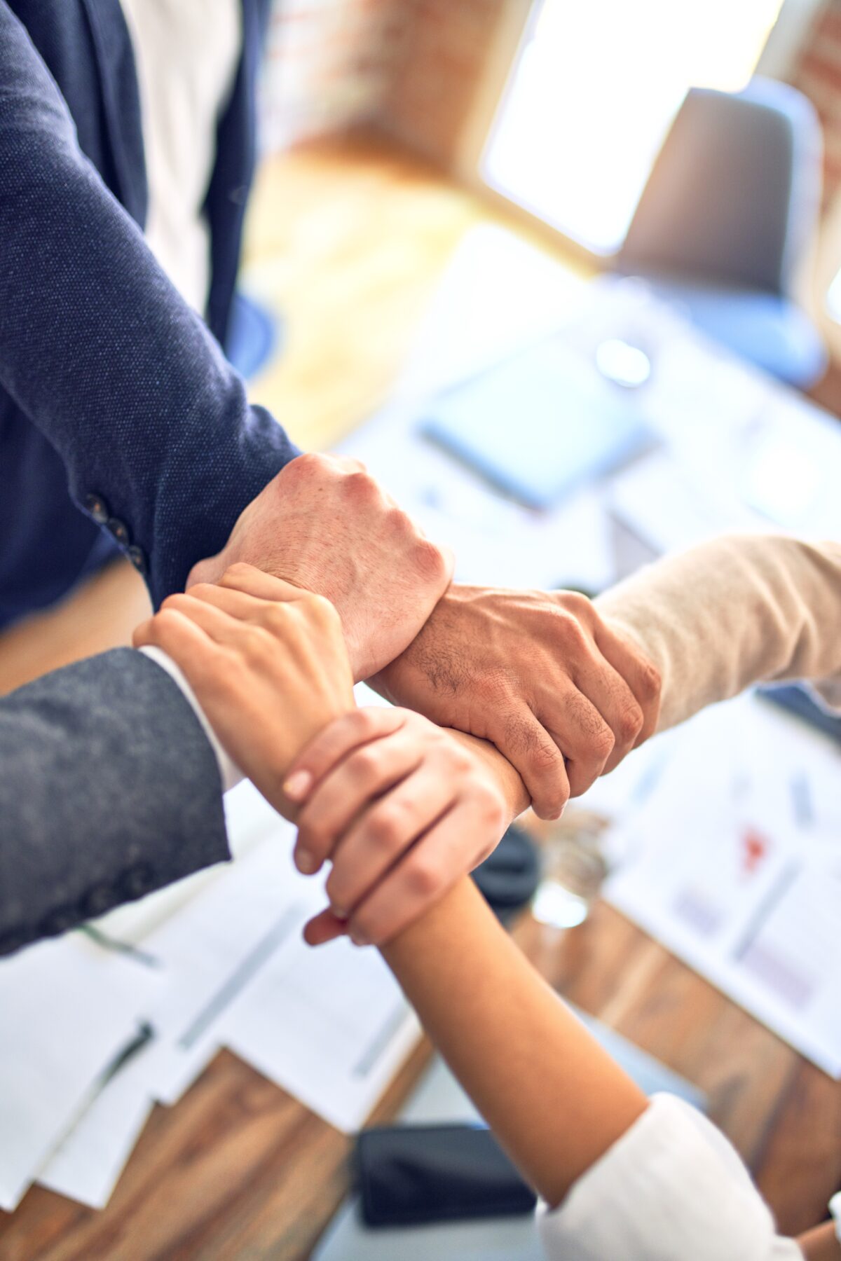 Four people's hands clasped together.