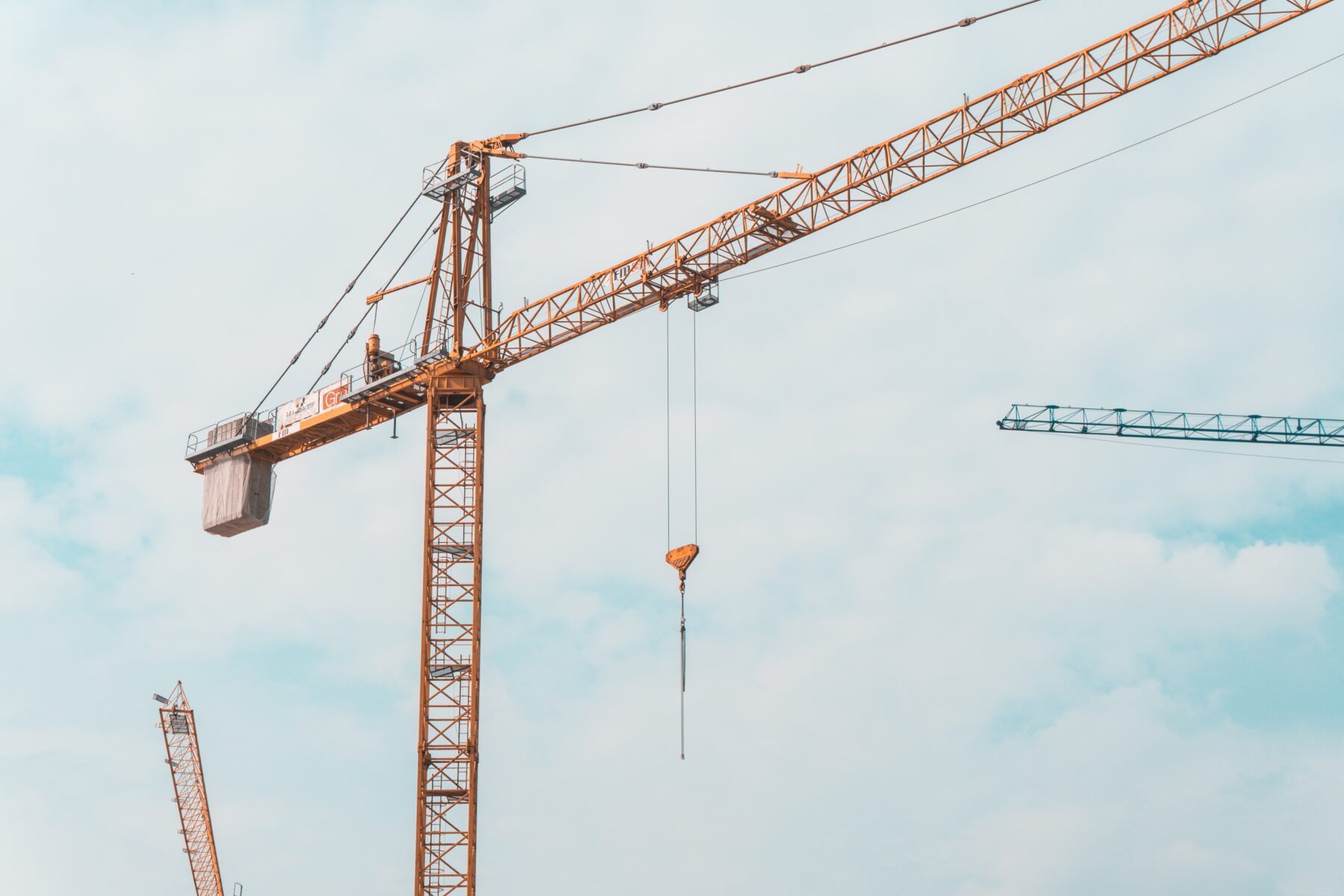 A yellow crane against a cloudy sky.