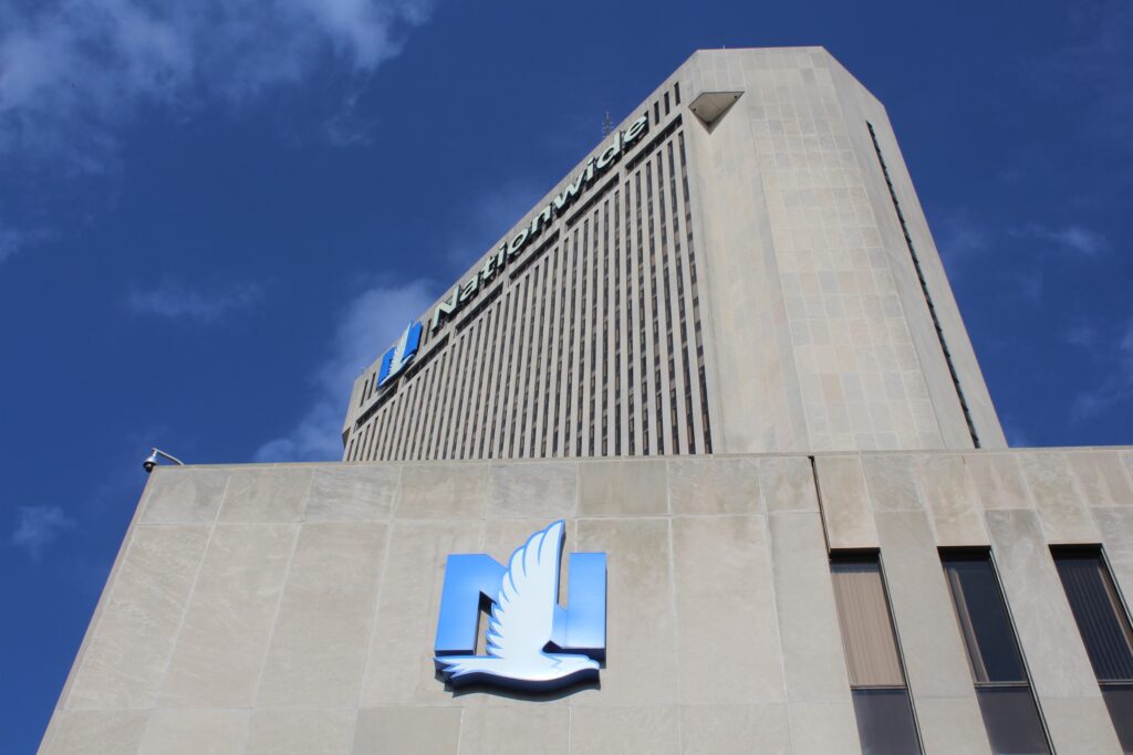 Nationwide headquarters: a gray concrete building against blue sky, with the blue N and white bird Nationwide logo.