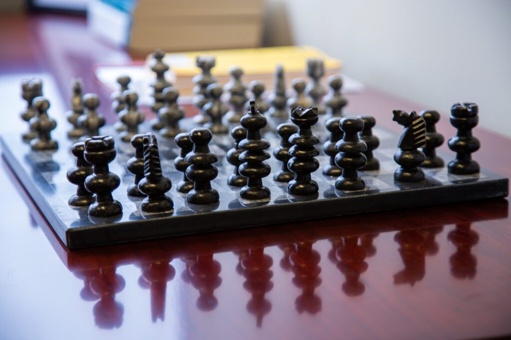 A chess set sitting on a warm wood table