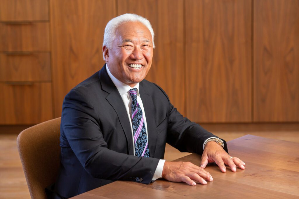Mark Kamitomo seated at a wooden table