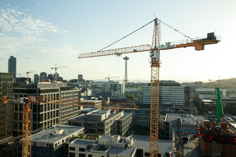 A large yellow rooftop crane over a city skyline