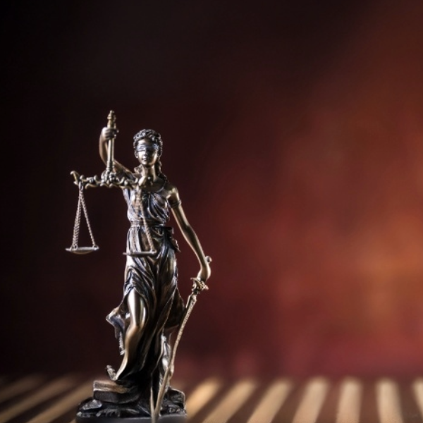 Bronze statue of blind Justice holding a sword and scales